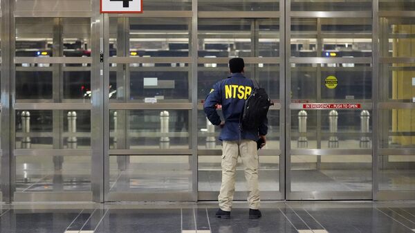 Член Национального совета по безопасности на транспорте (NTSB) стоит у двери в Национальном аэропорту имени Рональда Рейгана в Вашингтоне  - Sputnik Таджикистан